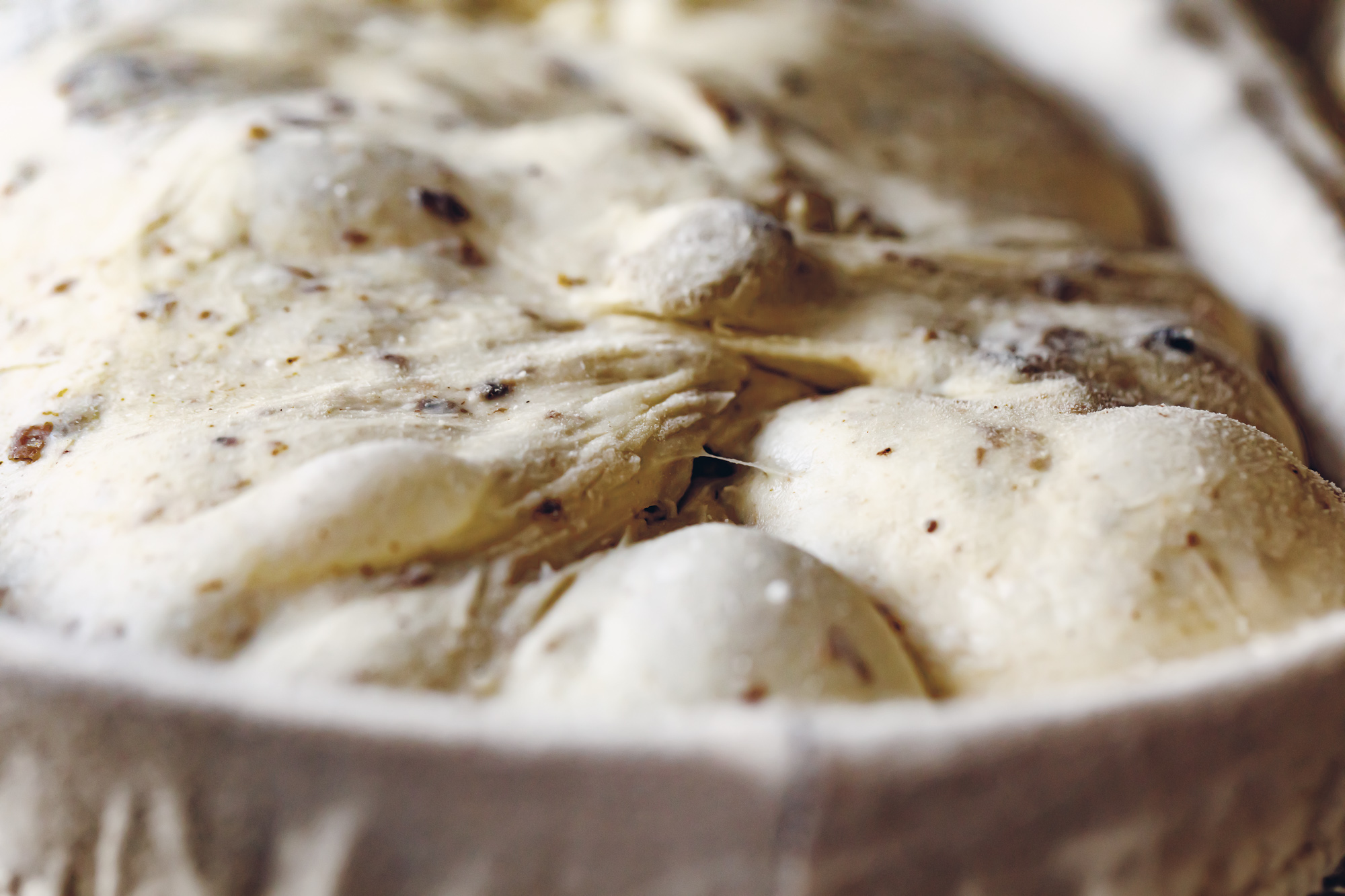 Close-up of seeded sourdough dough proofing in a banneton