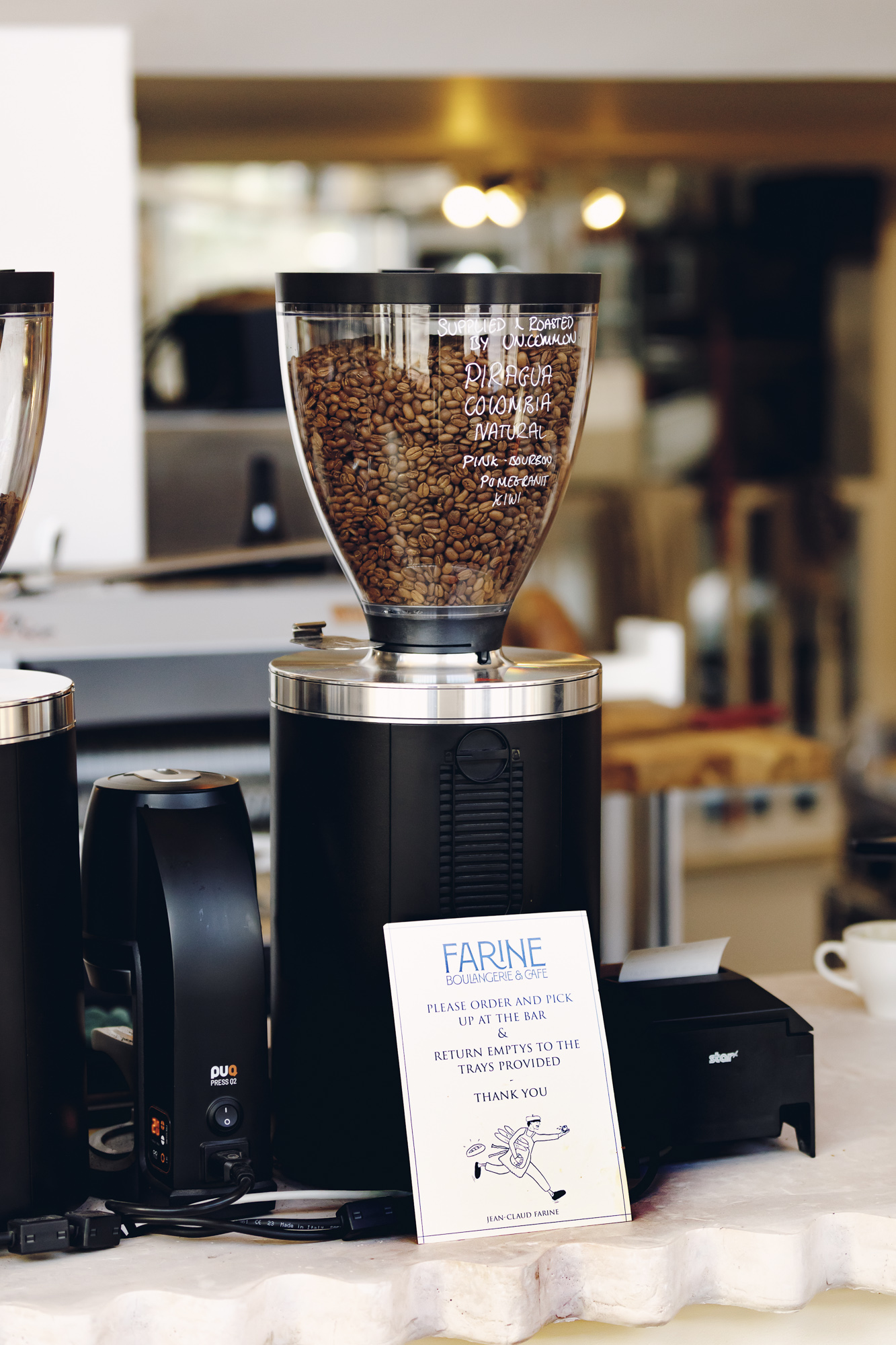 Coffee grinder filled with UNCOMMON Piragua Colombia natural beans at Farine